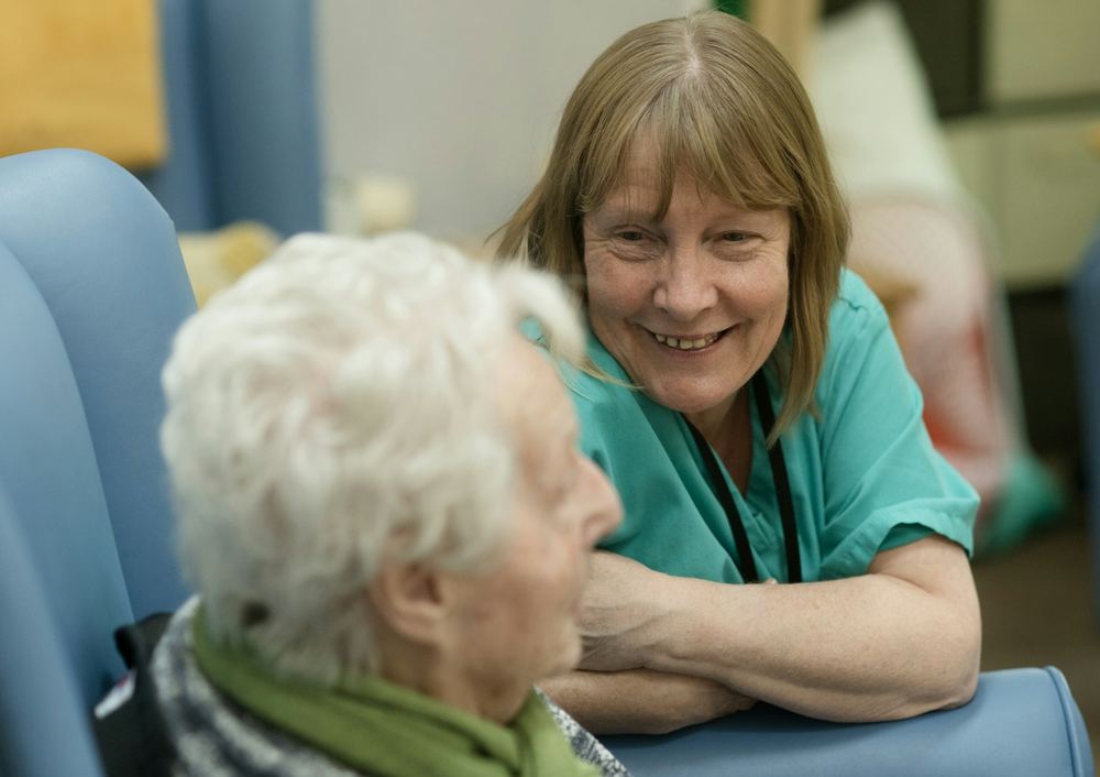 A nurse laughing with an older woman